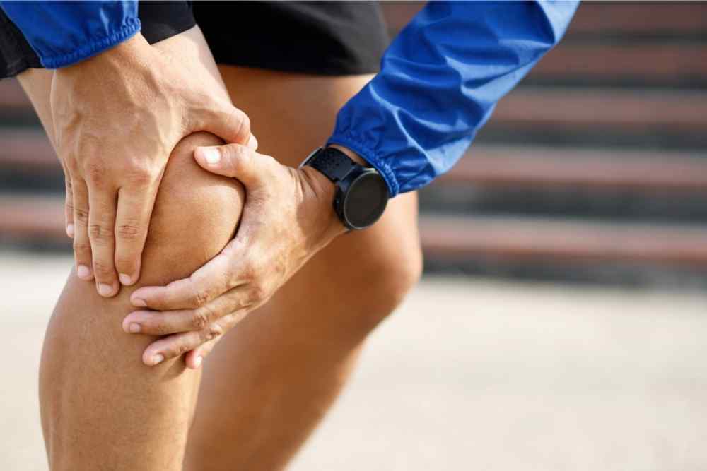 runner holding knee in pain