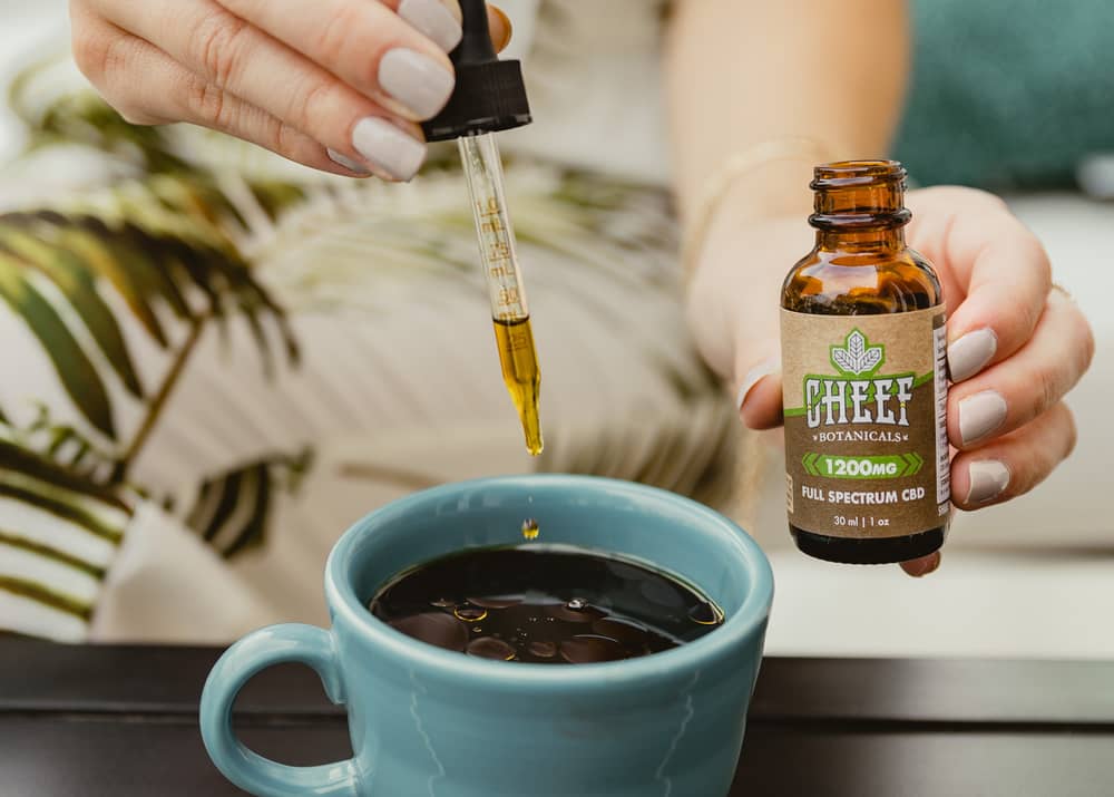 dropping cbd oil into morning coffee