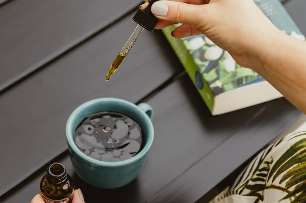 dropping tincture droplets into a nice cup of joe