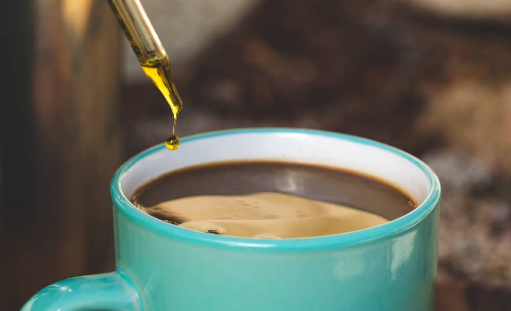 dropping oil into cup of joe