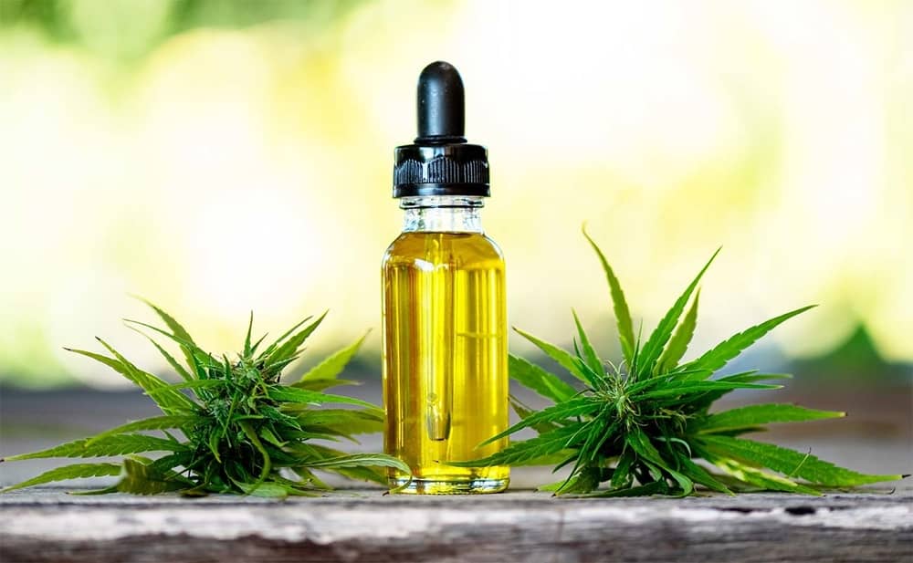 bottle of cbd oil with plants