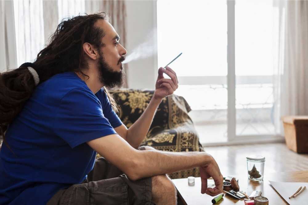 guy smoking cbd in living room