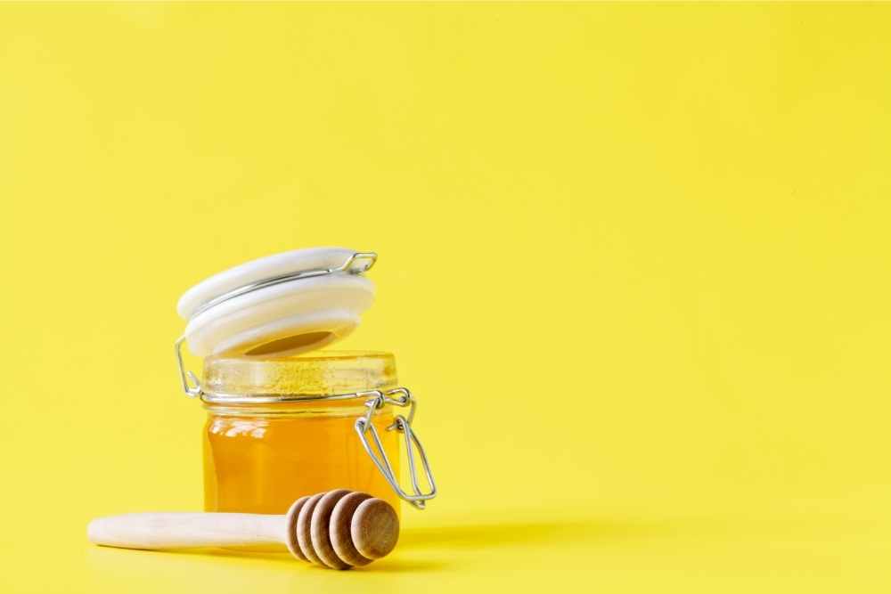 jar of honey with dipper