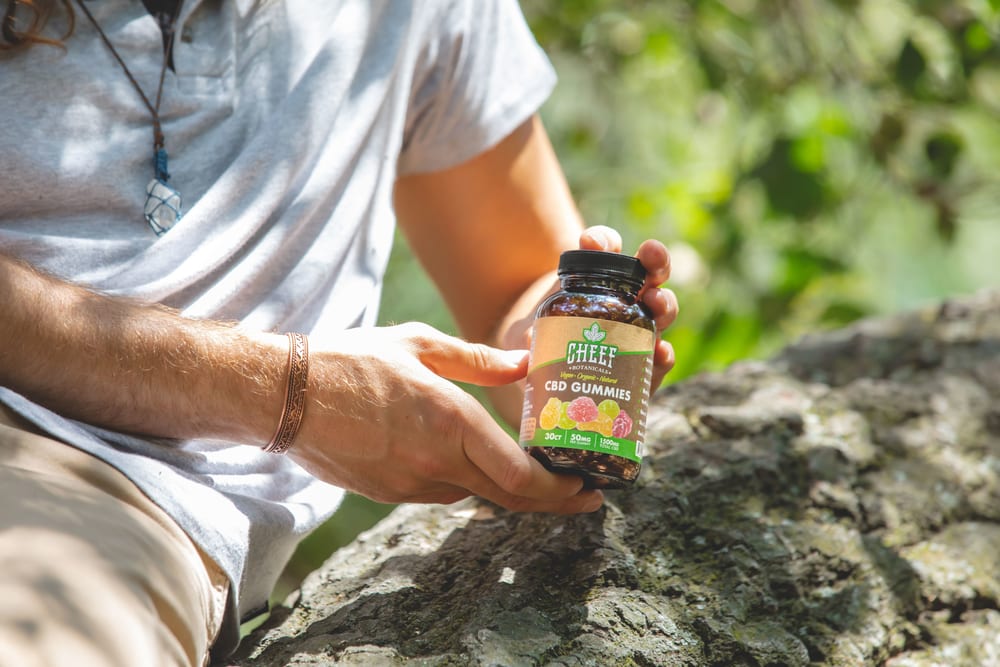 guy holding gummies in a tree