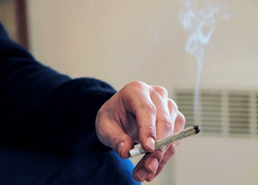 man holding cbd preroll joint