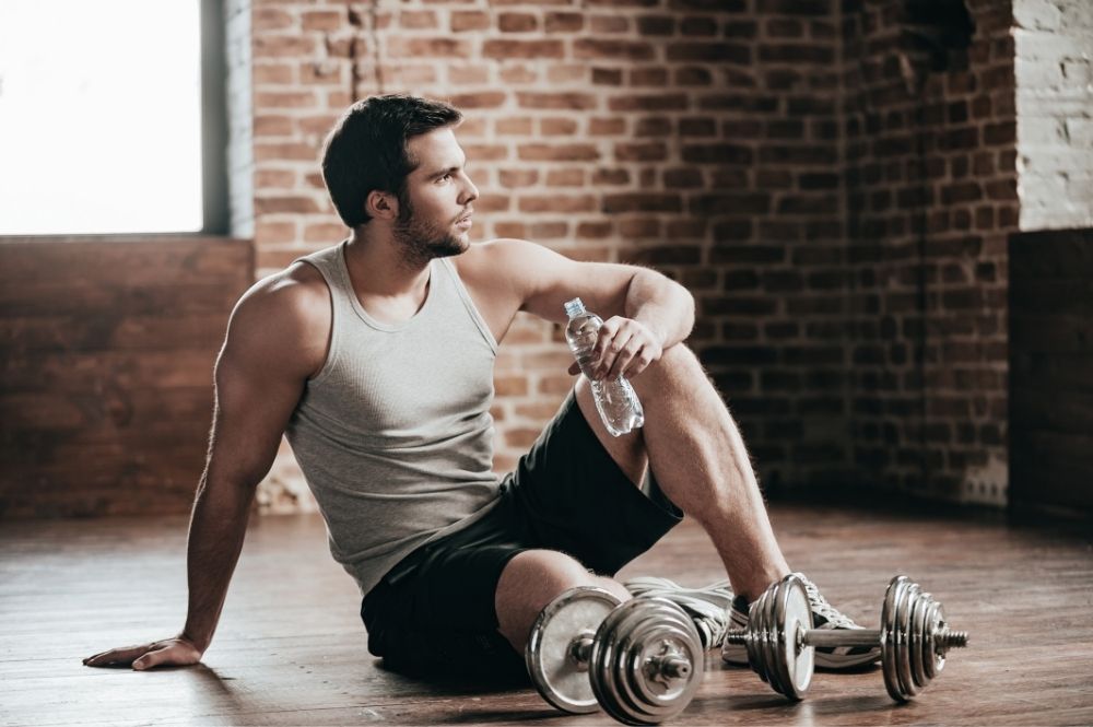 man in tank top with weights