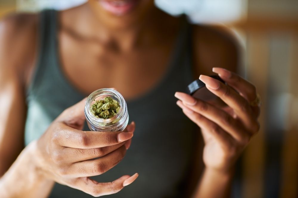 woman opening jar of buds