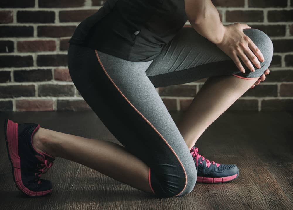 woman stretching out sore knee