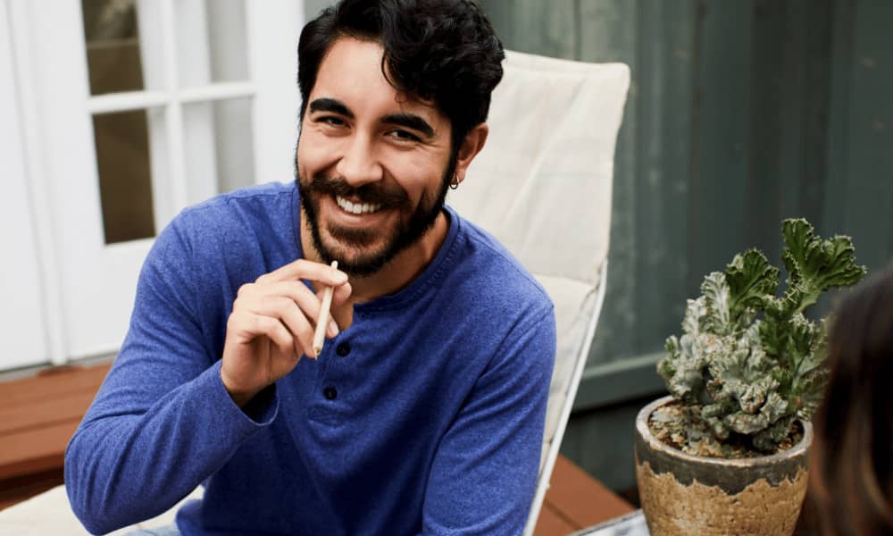 man happily smoking on patio