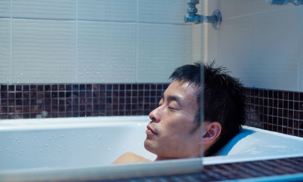 man in black tiled tub