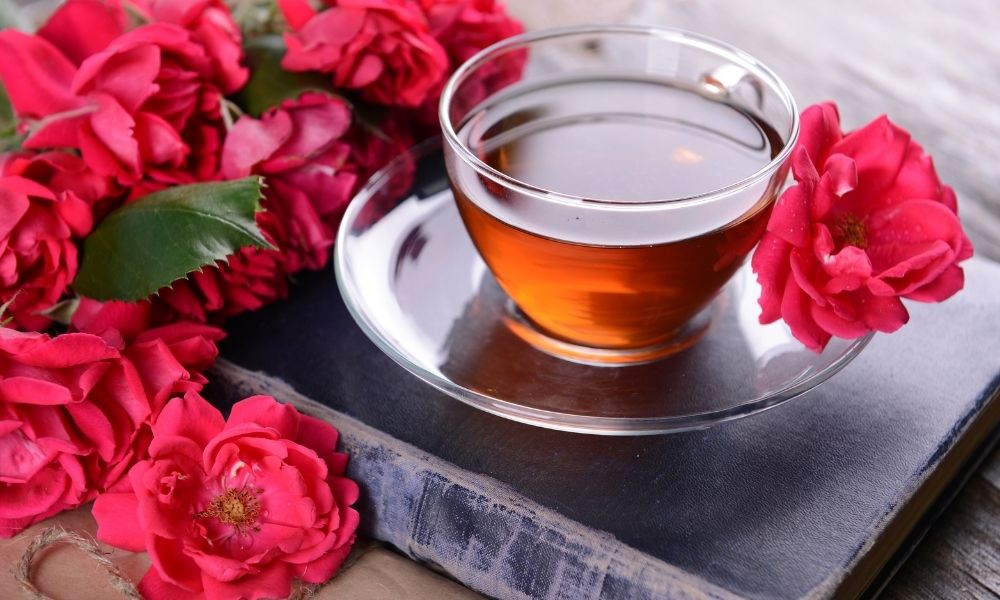 cup of rose tea on book