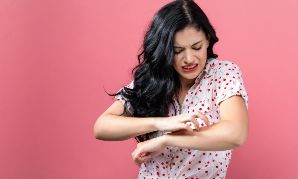 lady in polka dots scratching arm