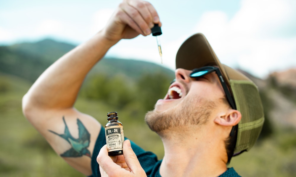 man dropping cbd tincture into his mouth