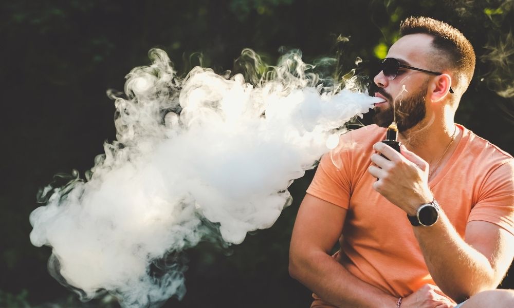 a man blowing a large cloud of vapor
