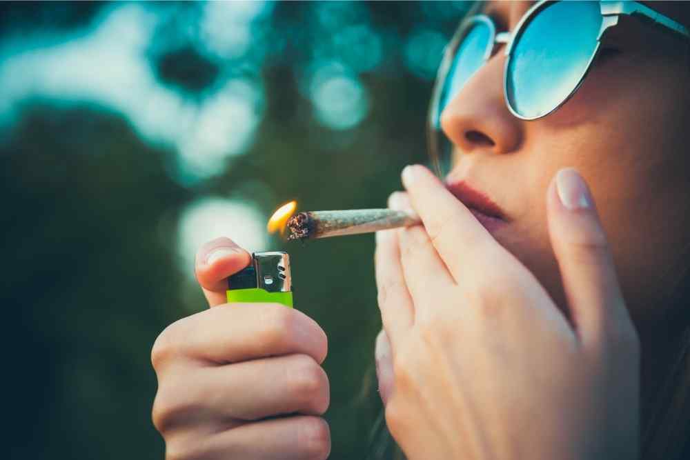 woman lighting up rolled joint