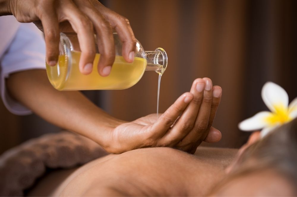 masseuse pouring oil into hand