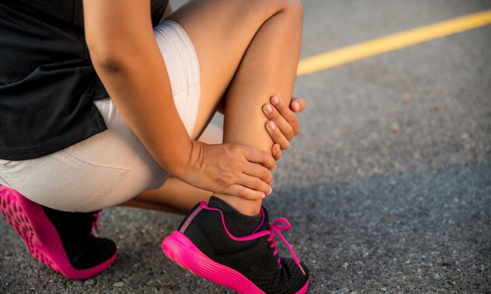 athletic woman bracing her right leg after running