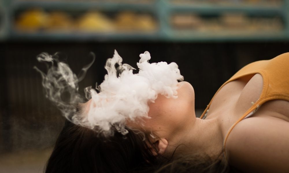woman lying down exhaling smoke