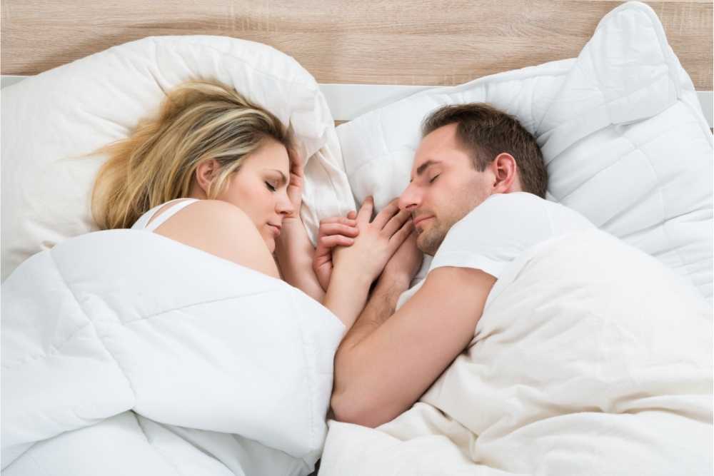 couple sleeping peacefully in white bed