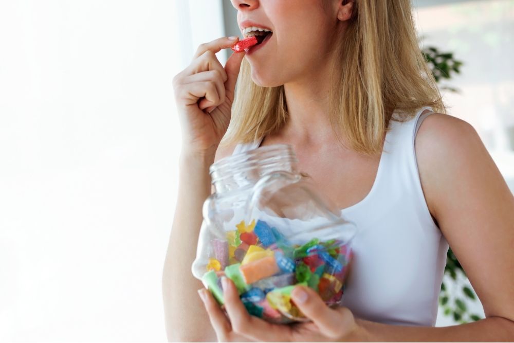 woman eating gummies from a container