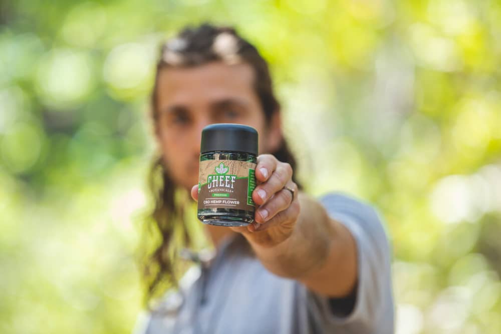 man holding bottle of CBD flower