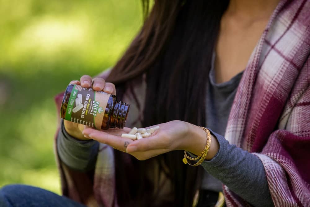 woman pouring cheef cbd capsules in hand