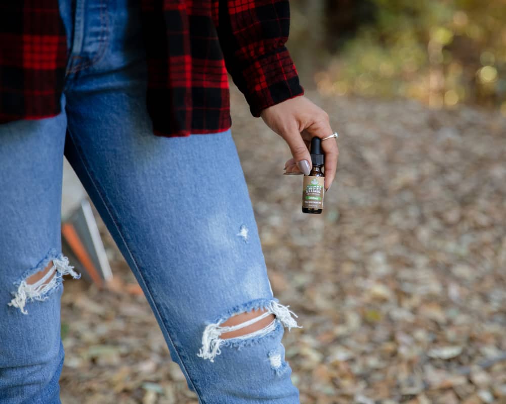 girl in forest with cbd tincture