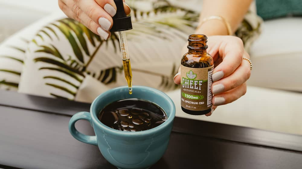 dropping cbd oil in cup of coffee