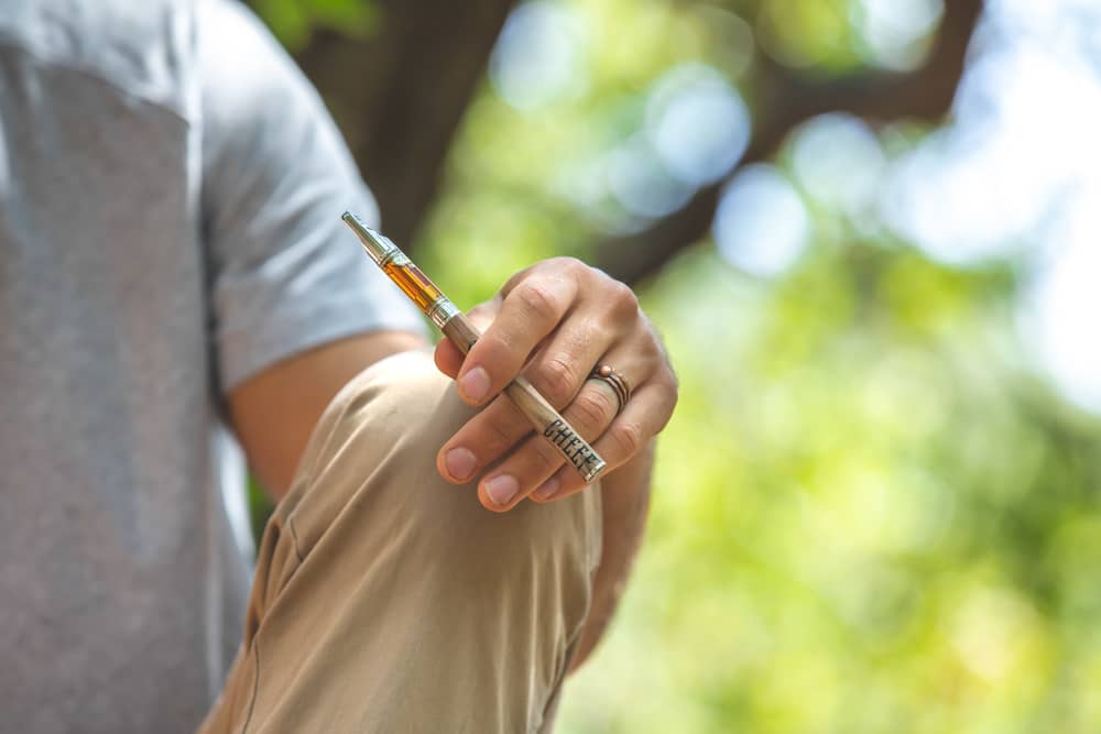 mans hand holding cheef vape pen