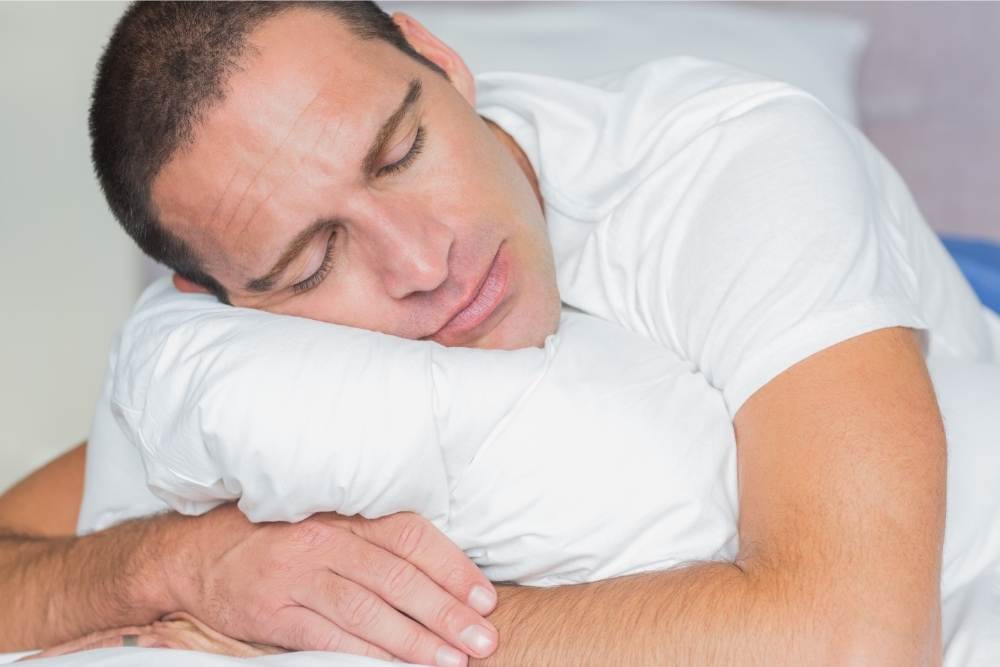 satisfied man hugging pillow