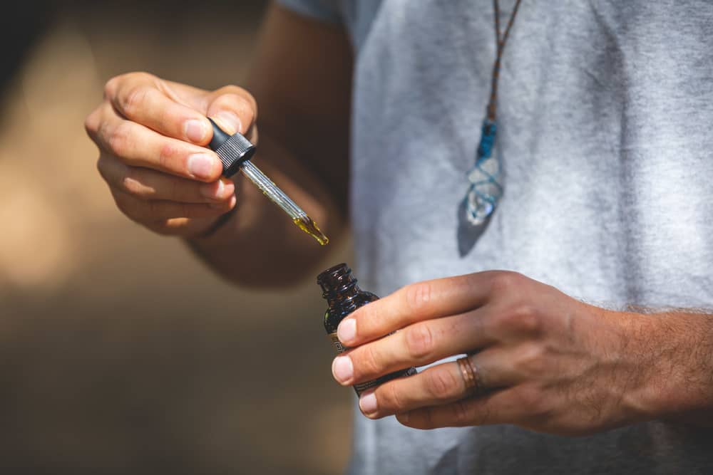 man holding free cbd oil tincture