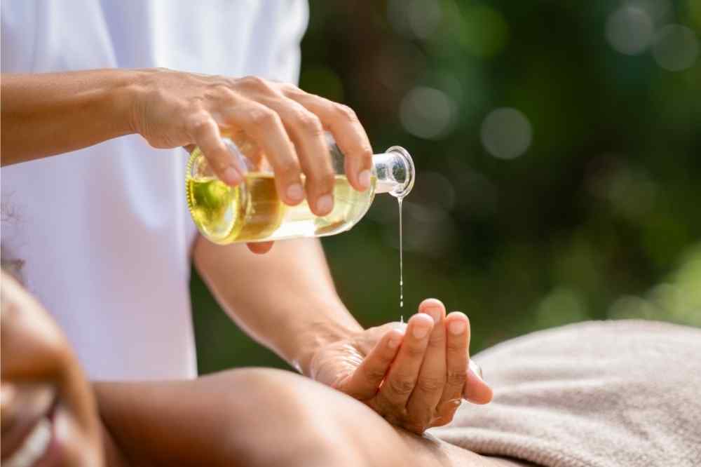 masseuse pouring mixture on hands