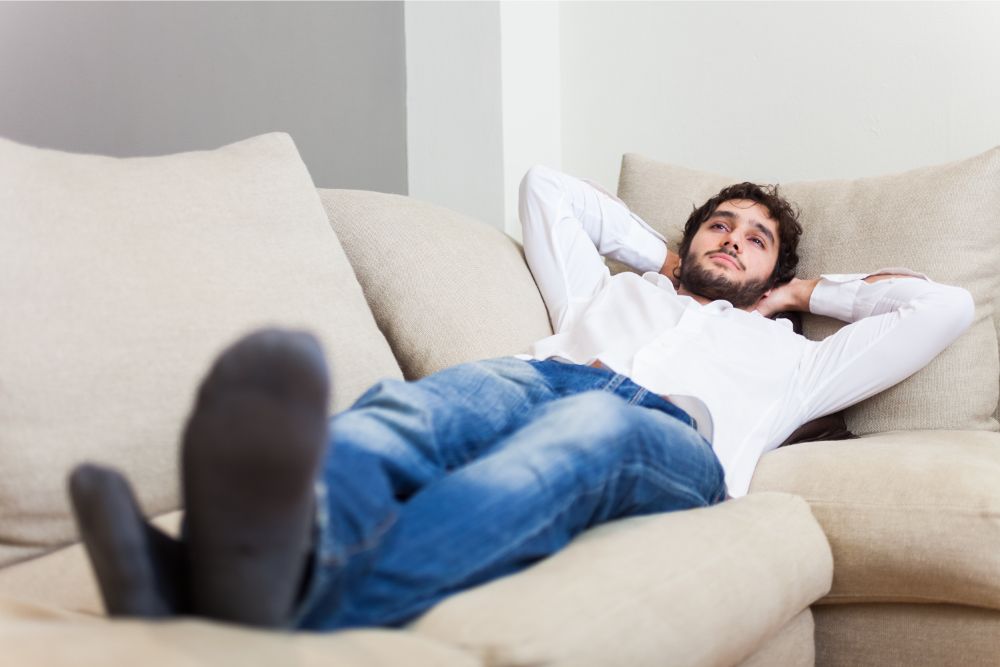 happy man relaxing on white sofa