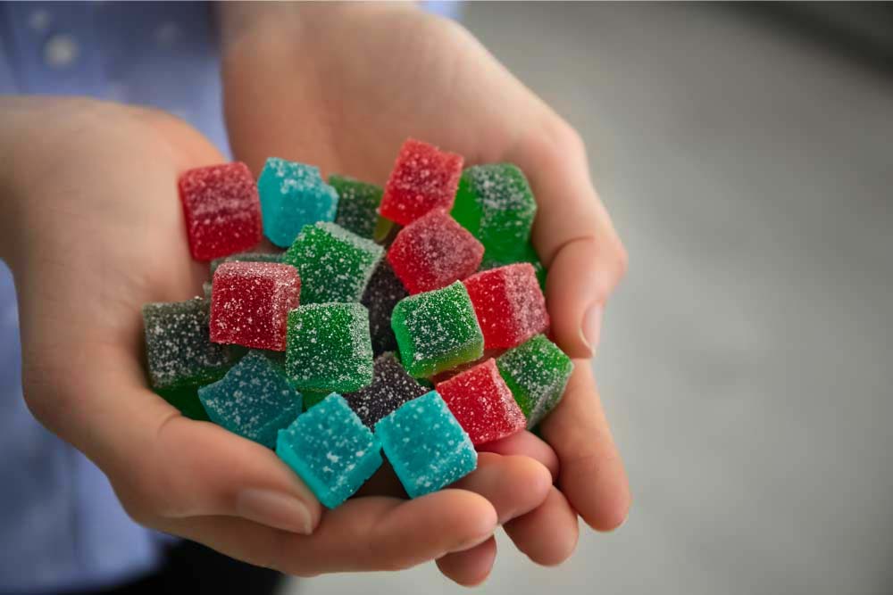 person holding thcp gummies outstretched
