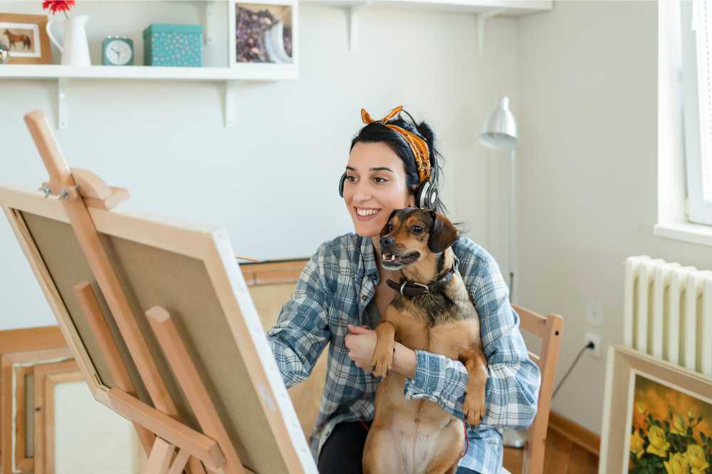 young woman artist happy holding dog