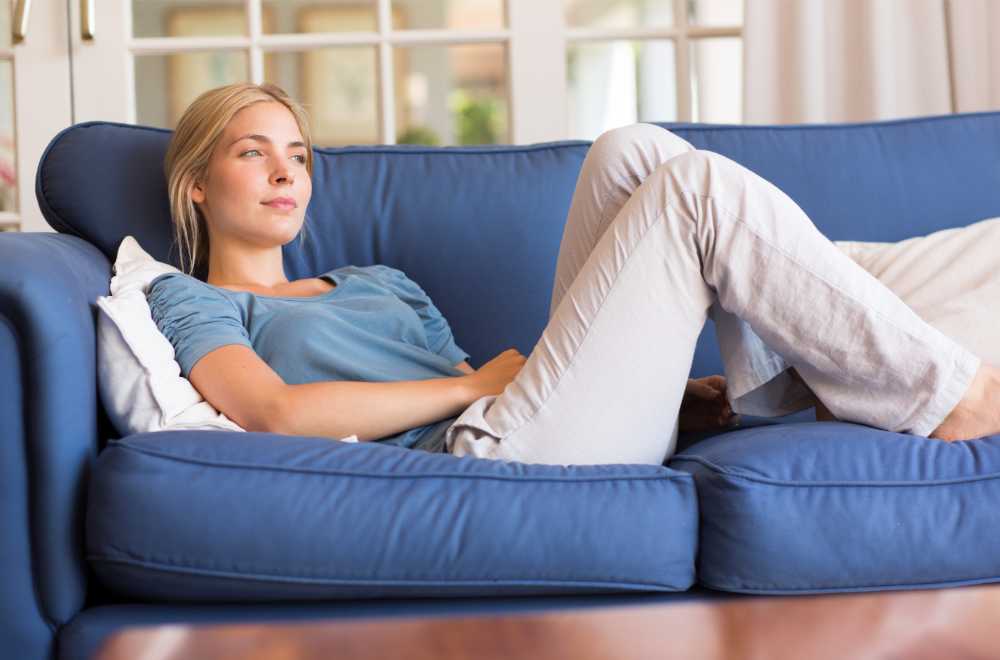 thoughtful woman relaxing on couch after smoking thcp