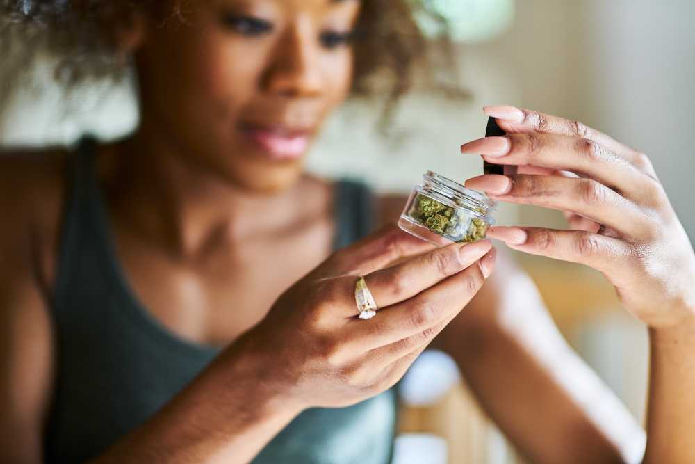 woman opening a jar of cannabis