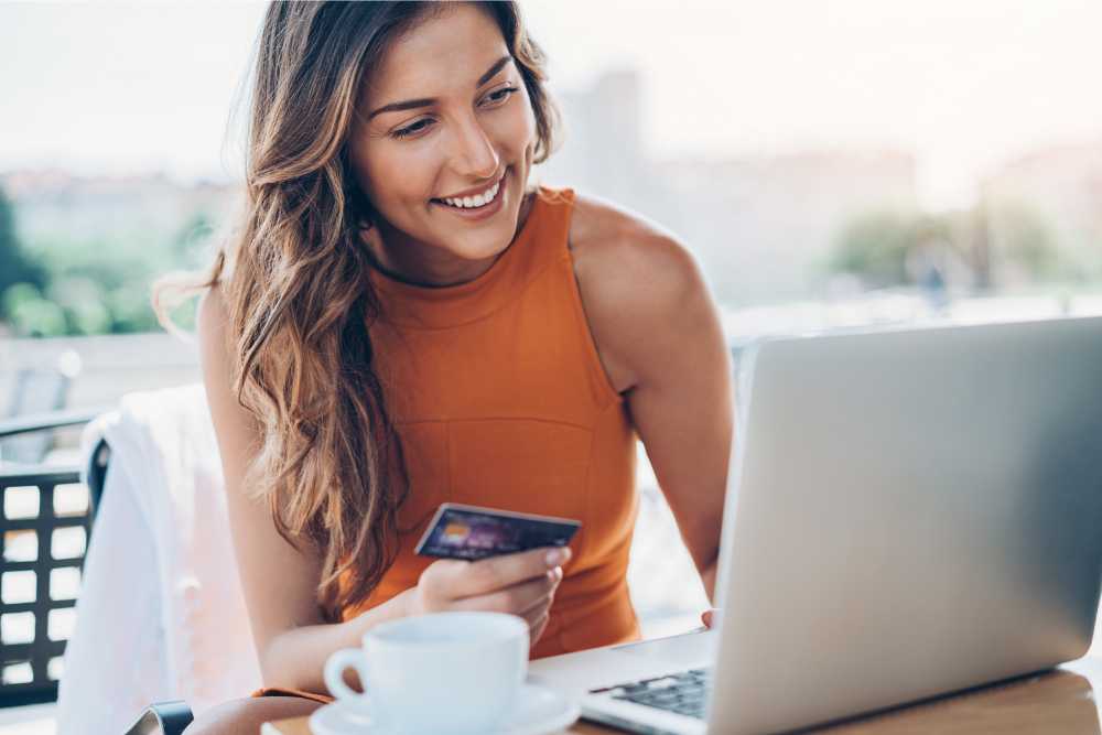 woman shopping on computer holding credit card